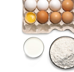 Raw eggs, glass of milk and flour