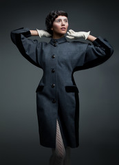 Fashion model brunette in blacl coat and white gloves
