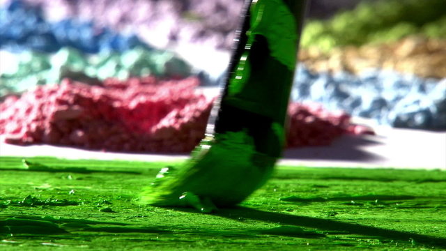 Paintbrush mixing green paint. Art studio shot.