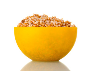Boiled buckwheat in a yellow bowl isolated on white