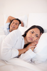 Fototapeta premium Displeased woman lying next to snoring boyfriend
