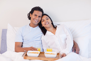 Obraz na płótnie Canvas Couple enjoying breakfast in the bed