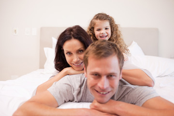 Obraz premium Playful family spending time in the bedroom