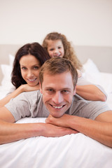 Obraz premium Cheerful family relaxing on the bed together