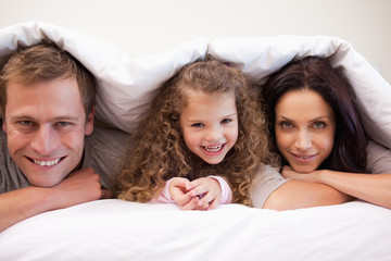 Family hiding under their blanket