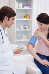 Obraz premium Doctor analyzing patients blood pressure