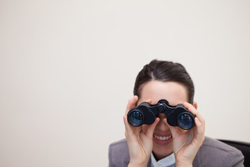 Businesswoman looking through binoculars