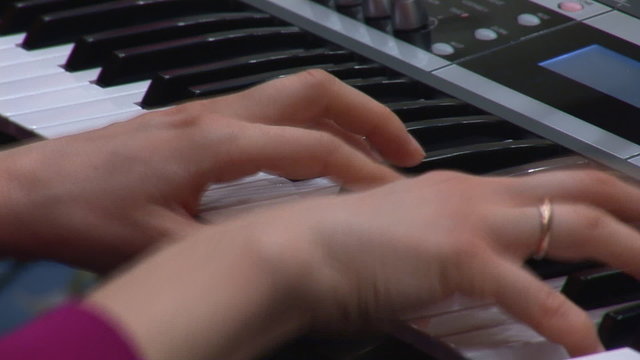 woman's hands playing a keyboard