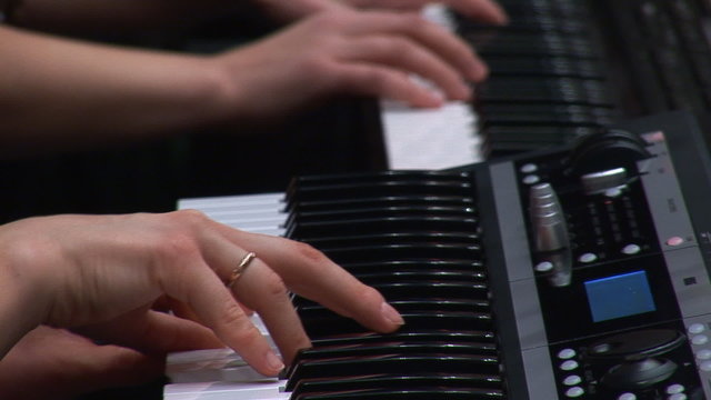woman's hands playing a keyboard