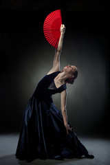 young woman dancing flamenco on black