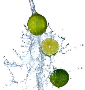 Fresh limes falling in water splash,isolated on white background