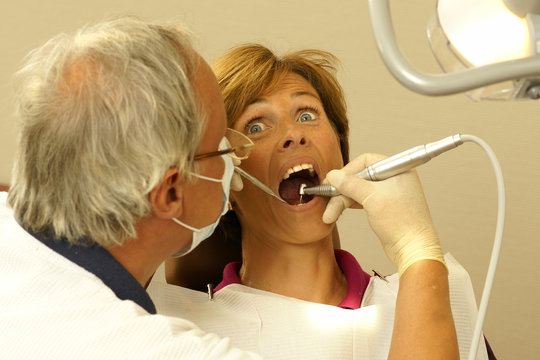 Frau beim Zahnarzt hat Schmerzen