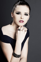 beautiful girl with perfect skin in black dress with jewelry