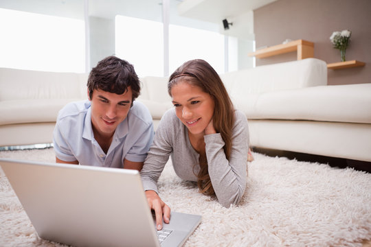 Couple with laptop on the floor