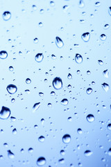 Beautiful abstraction with water drops over blue glass backgroun