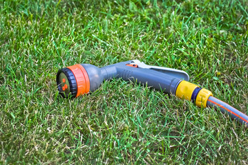 Lawn sprinkler - watering garden equipment on green grass.