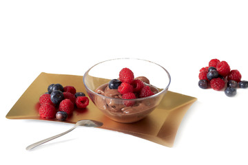 chocolate mousse with red fruits on golden plate