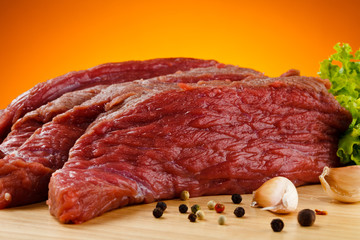 Raw beef on cutting board and vegetables