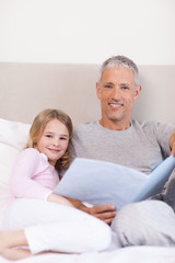 Obraz premium Portrait of a father reading a story to his daughter