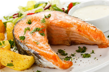 Grilled salmon, baked potatoes and vegetables