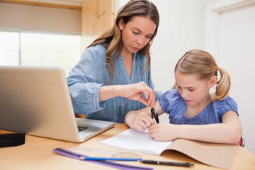 Fototapeta premium Woman helping her daughter doing her homework
