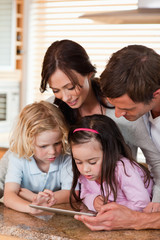 Fototapeta premium Portrait of a happy family using a tablet computer together