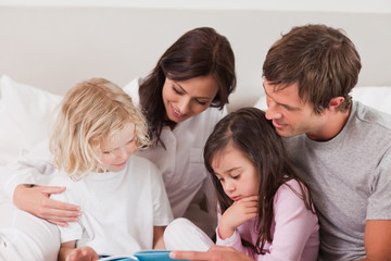 Obraz na płótnie Canvas Lovely family reading a book