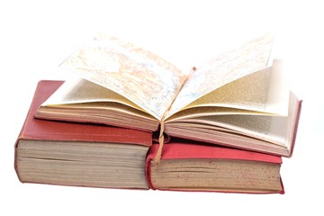 three old books with an open map on white