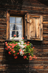 Fenêtre en bois garnies de géraniums