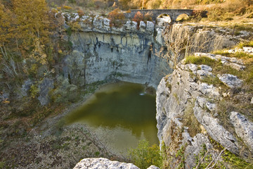 Stone bridge, pond and the cliff