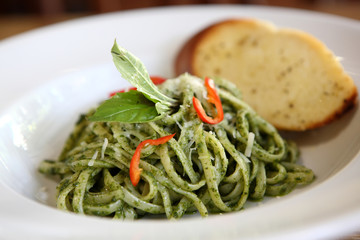 spaghetti with pesto sauce on wood background