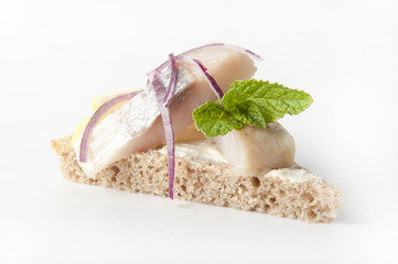 Sandwiches of rye bread with herring, onions and herbs.