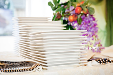 Stacks of white plates for a buffet.