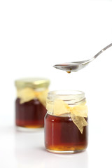 honey dripping from drizzler on top of jar, 