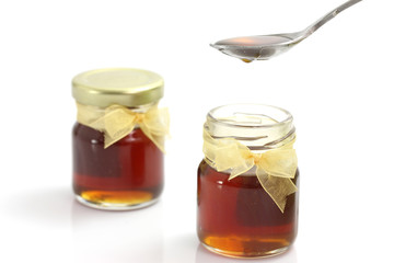 honey dripping from drizzler on top of jar, 