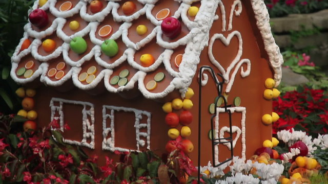 Gingerbread house decorated with fruit and flowers