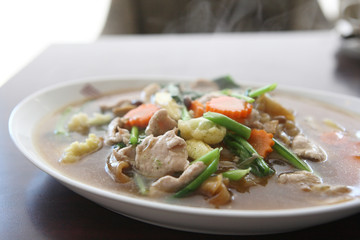 Thai food Wide Noodles in a Creamy Sauce with pork