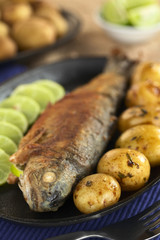 Fried trout with lime slices and potatoes
