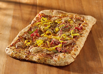 gourmet pizza with sausage and colorful peppers