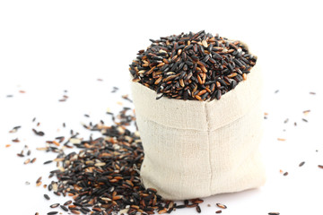 Brown rice in small burlap sack isolated in white background