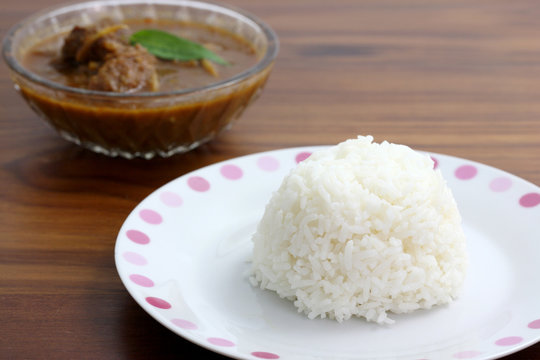 Thai food pork curry with rice in wood background