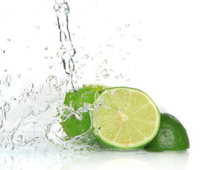 Green limes with splashing water