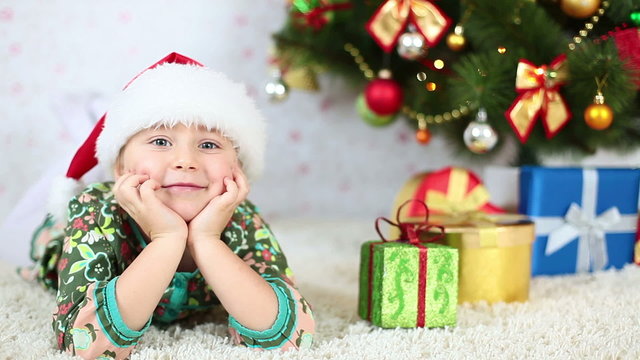 Laughing girl lying near to the Christmas Tree