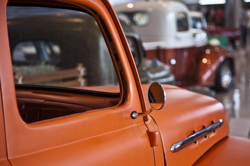 Old orange pickup truck car sideview mirror. Rear view mirror.