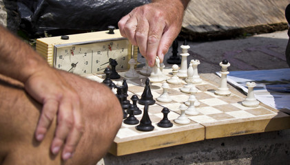 Chess board and hands of people