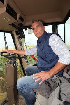 Farmer sitting in the cab of a combine harvester