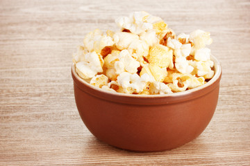 popcorn in brown bowl on wooden table
