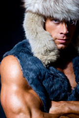 Strong athletic man in a fur cap