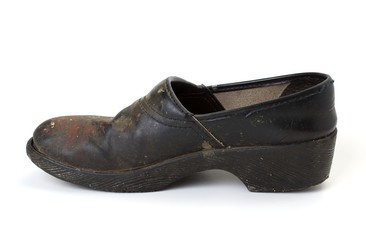 Side view of old dirty clog on a white background