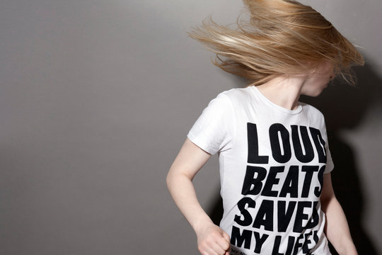 Junge Frau mit Tshirt sch&uuml;ttelt ihre Haare